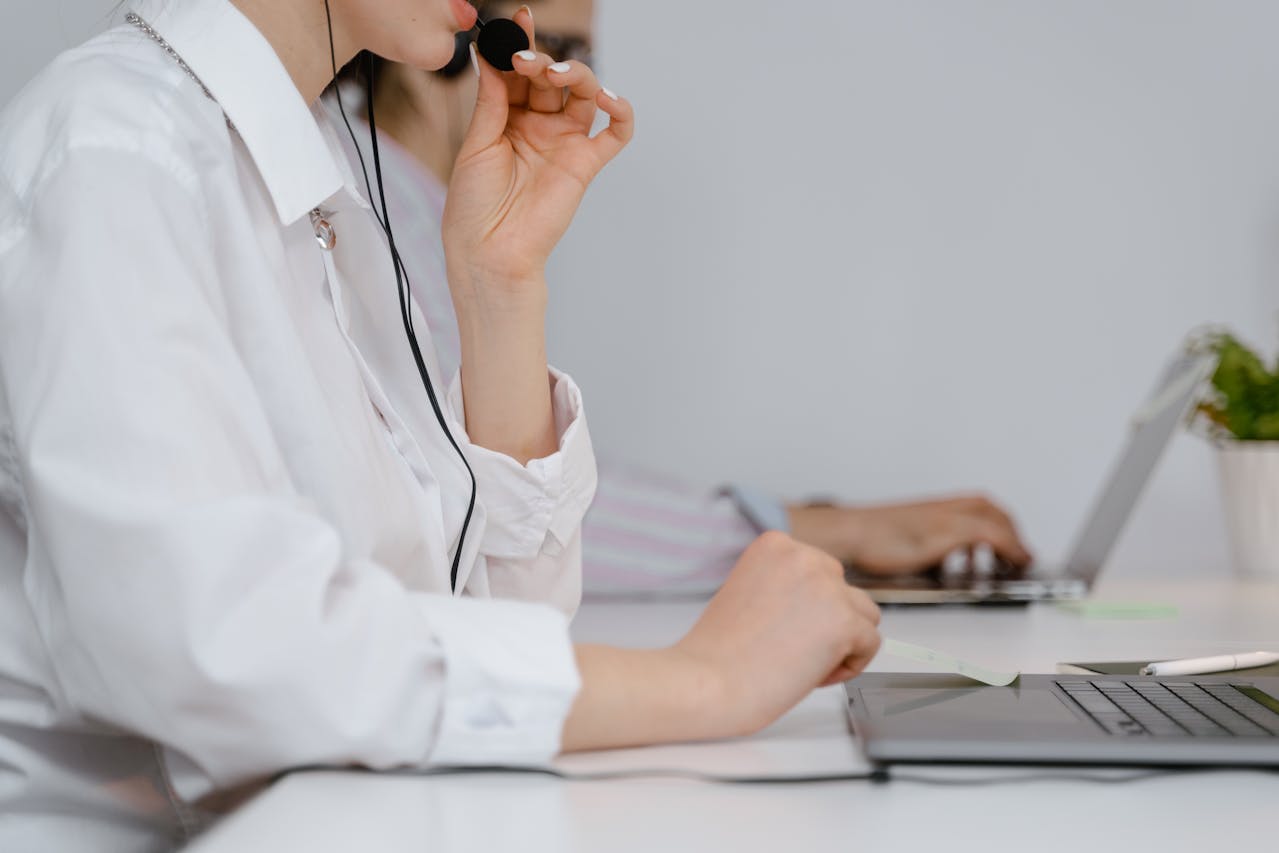 Foto di una donna che sta fornendo supporto tecnico dalla sua postazione helpdesk