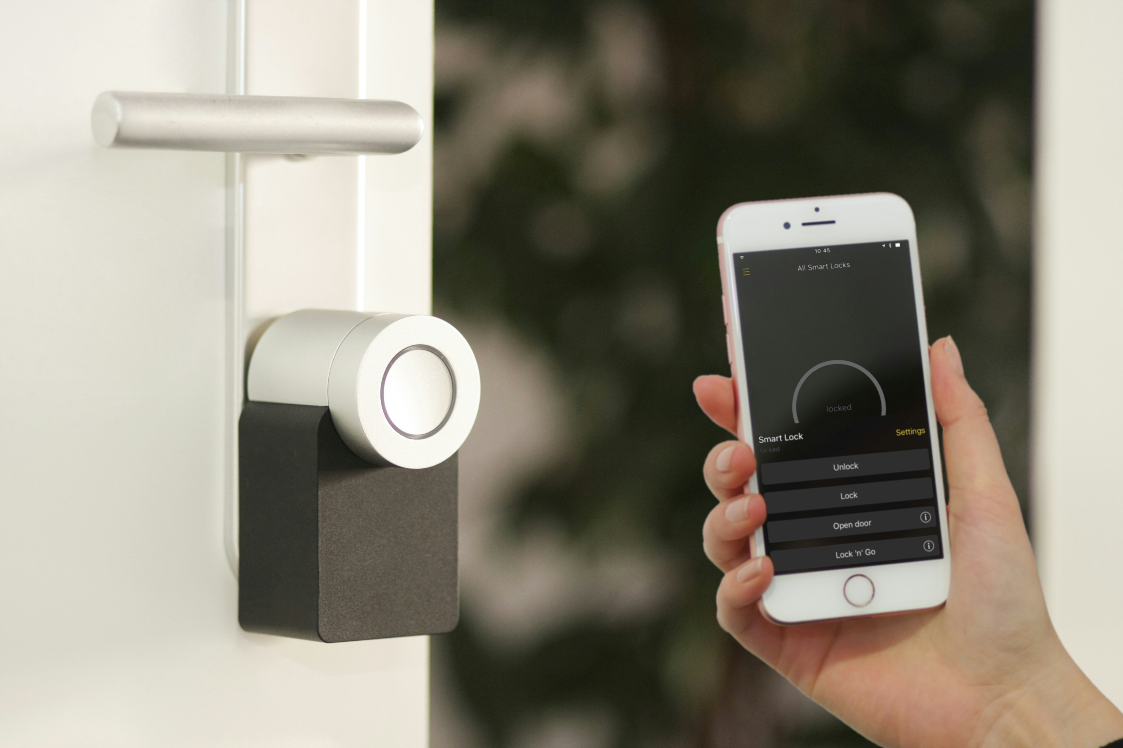 Una mano con uno smartphone che apre la porta Smart di casa