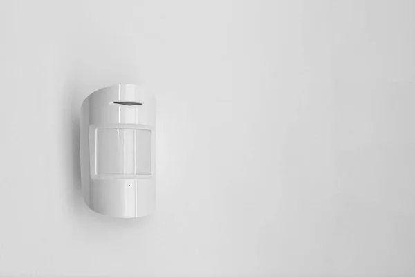 Un sensore di rilevamento montato su un muro bianco