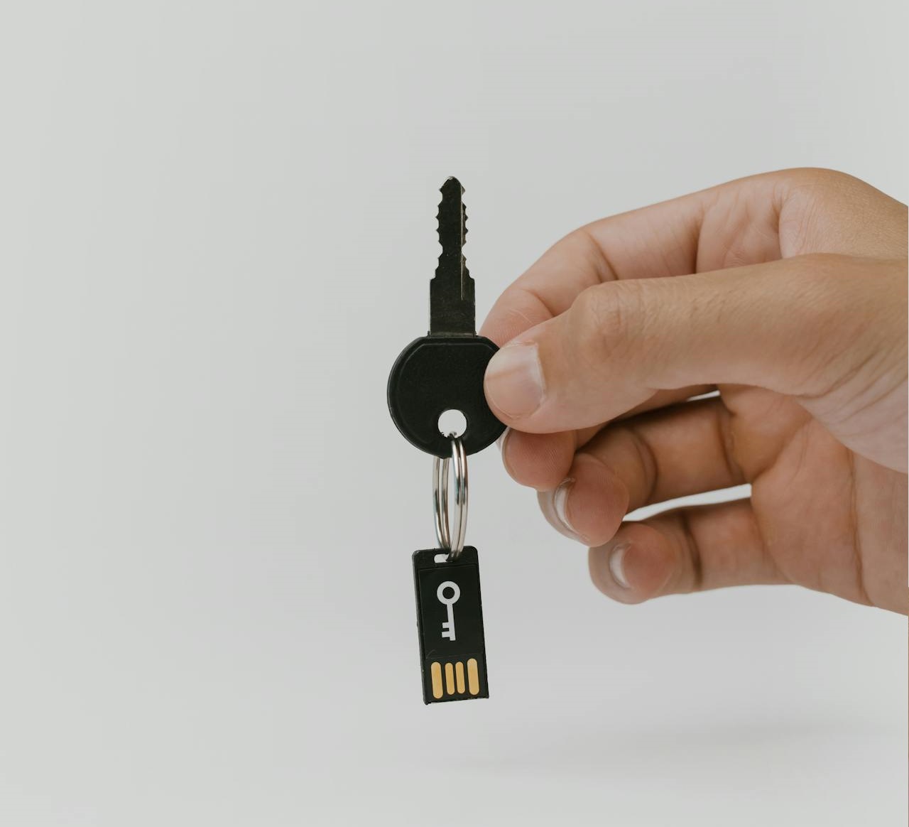 Foto di una mano che regge uno smartphone e in secondo piano dei dispositivi smart:lamapdine, sensori, prese elettriche